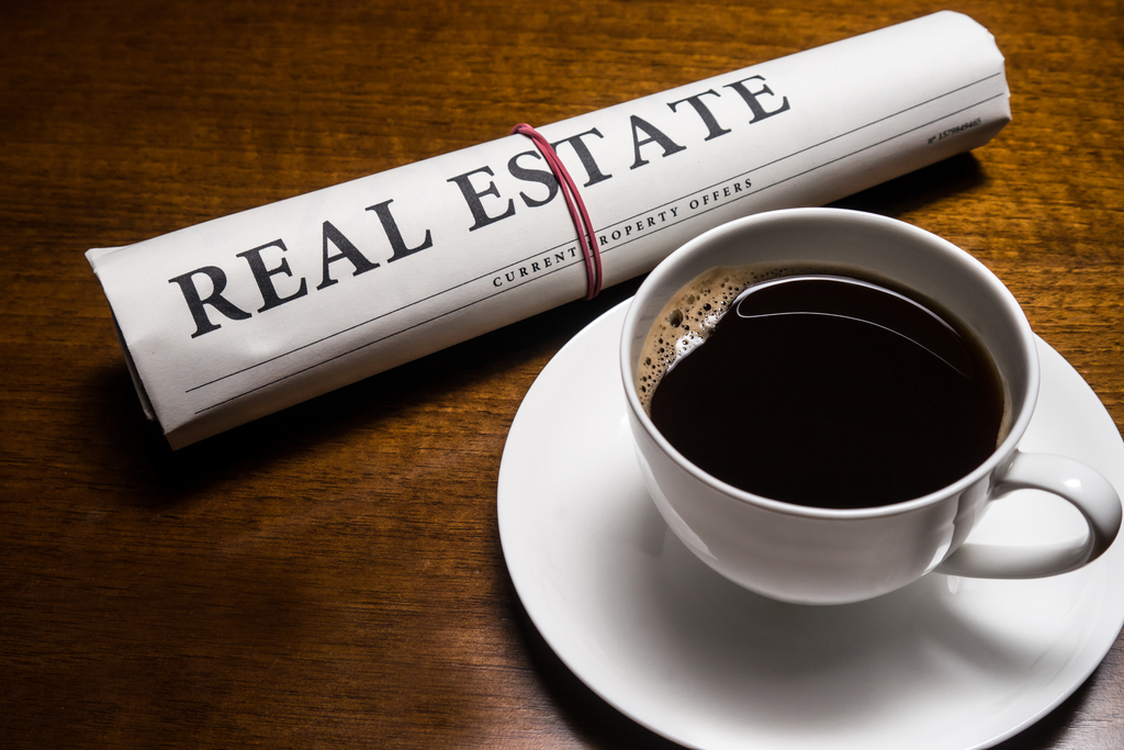 Real estate newspaper and cup of coffee